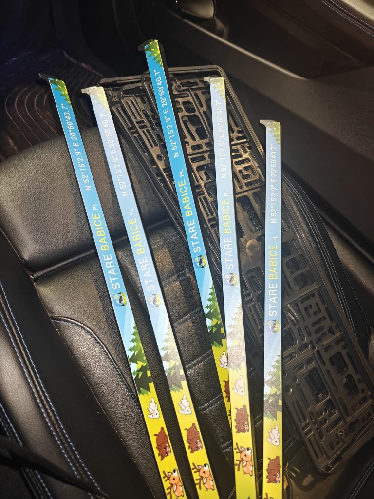 Ramki rejestracyjne Stare Babice na siedzeniu samochodu – komplet nowych ramek.